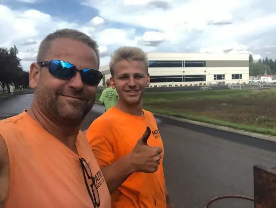 Gary Livingston and his son Kyler in Patriot Sealcoat shirts on a freshly sealcoated job site